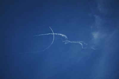 Low angle view of vapor trail against blue sky