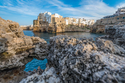 Scenic view of polignano a mare in apulia in italy against dramatic sunset sky