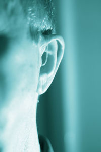 Close-up of man wearing hearing aid at home