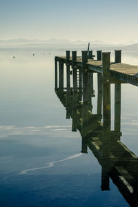 Pier on calm lake against sky