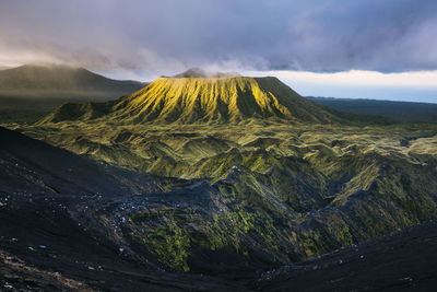 Scenic view of volcanic crater against cloudy sky