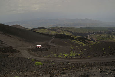 Cars on road in desert against sky