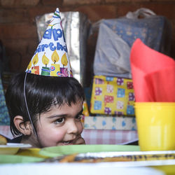 Close-up of boy wearing party hat at home