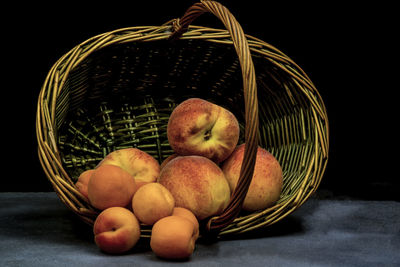 Apricots and peaches on wicker basket