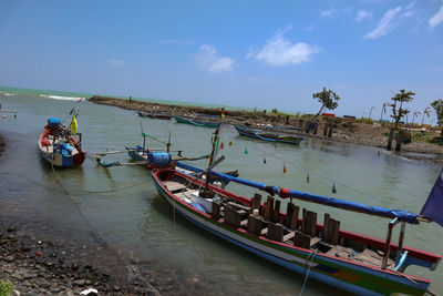 Boats moored in sea against sky