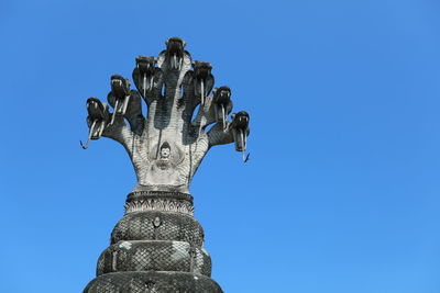 Low angle view of statue against clear blue sky