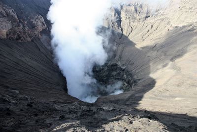 High angle view of smoke emitting from volcanic mountain