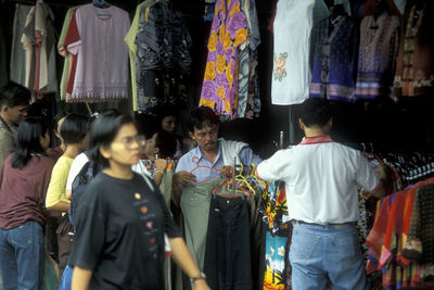 Rear view of people standing in market