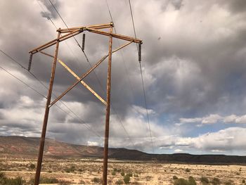 Low angle view of electricity pylon on land against sky