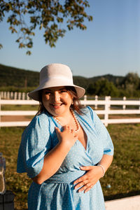 Portrait of smiling woman standing against sky