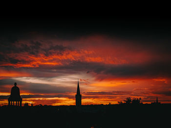 Silhouette buildings against sky during sunset