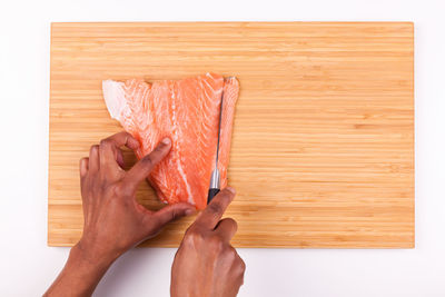 Close-up of hand holding bread on cutting board