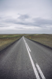 Empty road amidst field