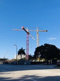 Cranes at construction site against sky