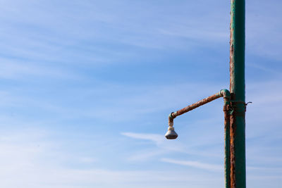 Low angle view of street light against blue sky