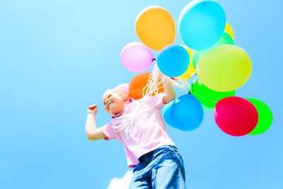 Low angle view of balloons against blue sky