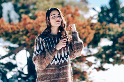 Smiling young woman standing outdoors