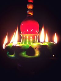 Close-up of lit candle in dark room