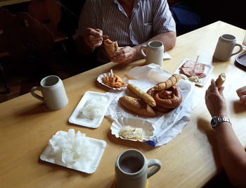 High angle view of man and coffee cup on table