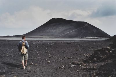 Man standing on mountain against sky
