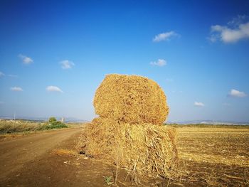 Hay bales on field against sky