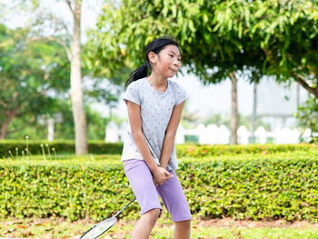 Portrait of smiling girl standing against plants