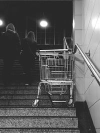Rear view of people walking on staircase at night