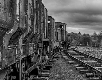 Old train on railroad track against sky