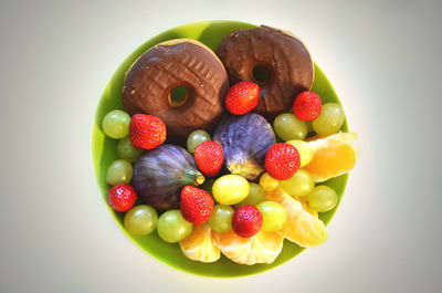 Directly above shot of fruits in plate against white background