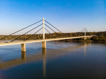 Bridge over river against clear blue sky