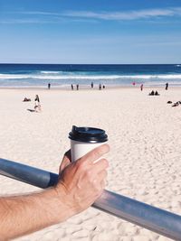 Close-up of man on beach against sky