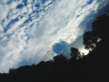 Low angle view of silhouette trees against sky