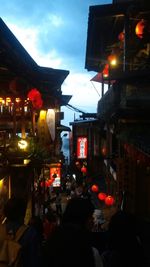 Woman standing on illuminated city street at night