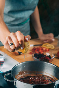 Fruit canning preservation. woman cooking fruits and making homemade jam. squeezing lemon.