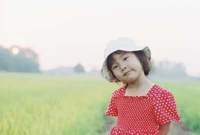 Girl looking away while standing on field