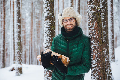 Portrait of smiling man standing in snow