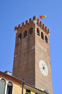 Low angle view of clock tower against clear blue sky