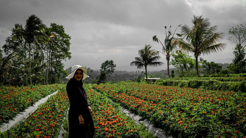 Full length of woman standing on field against sky