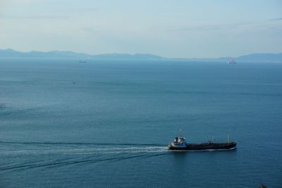 Container ship sailing in sea against sky