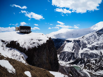 Scenic view of snow covered mountains against blue sky