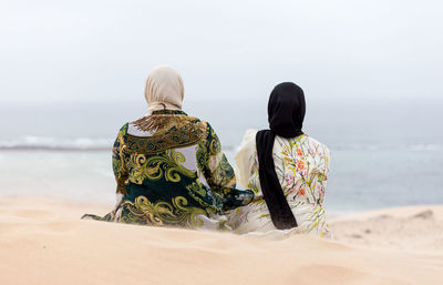 Rear view of woman looking at sea against sky