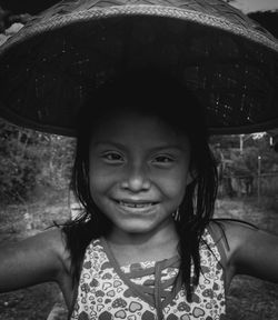 Portrait of smiling girl holding wicker basket over head