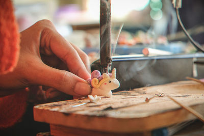 Cropped image of artist making figurine at factory