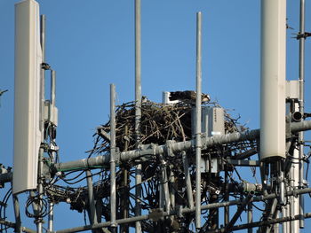 Low angle view of industry against clear blue sky