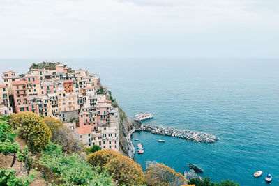 High angle view of townscape by sea against sky