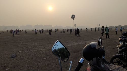 People on beach against sky during sunset