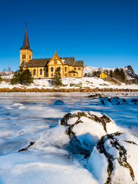 View of building during winter against blue sky