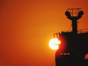 Silhouette lamp against orange sky during sunset