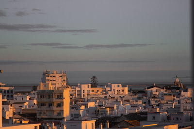 High angle view of townscape by sea against sky