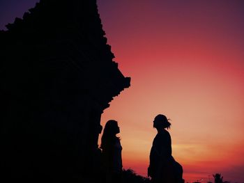 Silhouette people standing against sky during sunset